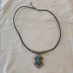 Turquoise necklace on black necklace.